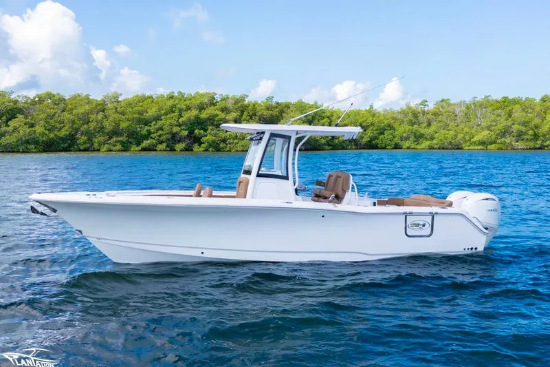 The Image of 2026 Sea Hunt Ultra 275 SE boat on blue water with lush green background. - 0