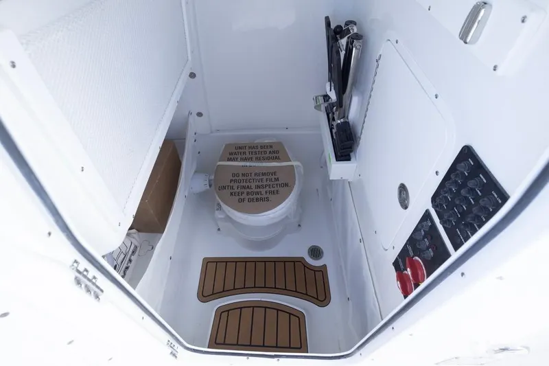 Slide: The Image of Interior of 2026 Sea Hunt Ultra 275 SE boat, featuring a compact marine toilet. - 16