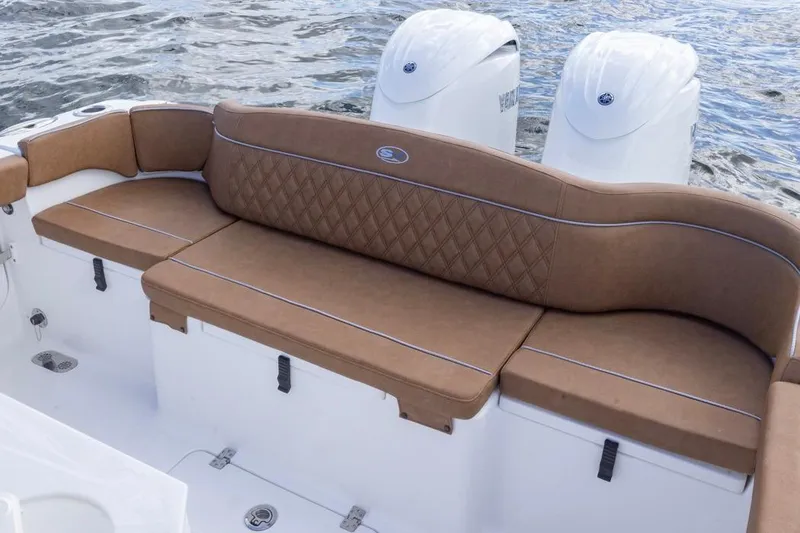 Slide: The Image of 2026 Sea Hunt Ultra 275 SE boat with brown cushioned seating and dual engines. - 24