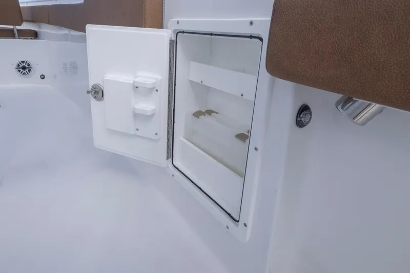 Slide: The Image of 2026 Sea Hunt Ultra 275 SE boat storage compartment with open door and brown seating. - 28