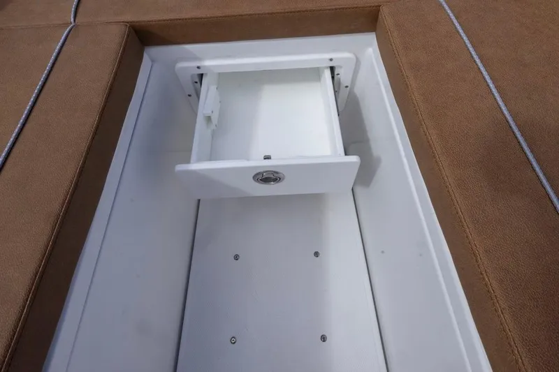 Slide: The Image of Open storage compartment on 2026 Sea Hunt Ultra 275 SE boat with brown seating. - 9