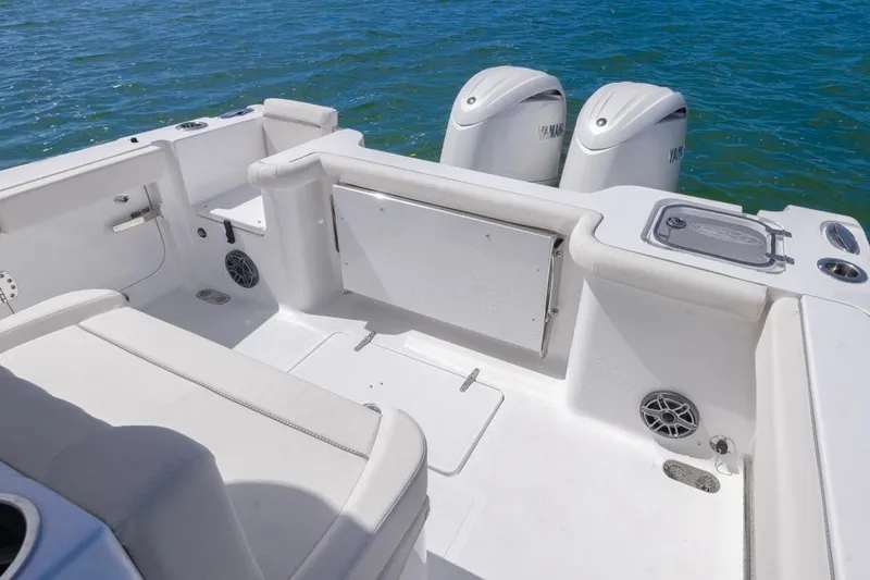 Slide: The Image of 2026 Sea Hunt Gamefish 27 boat interior with dual Yamaha engines, white seating, and ocean backdrop. - 13