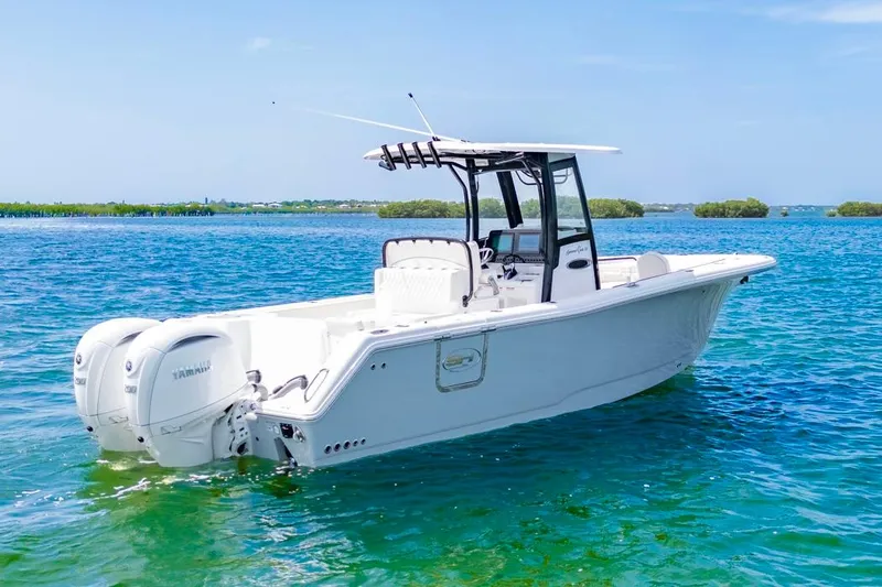Slide: The Image of 2026 Sea Hunt Gamefish 27 boat on clear blue water, featuring dual Yamaha engines. - 2