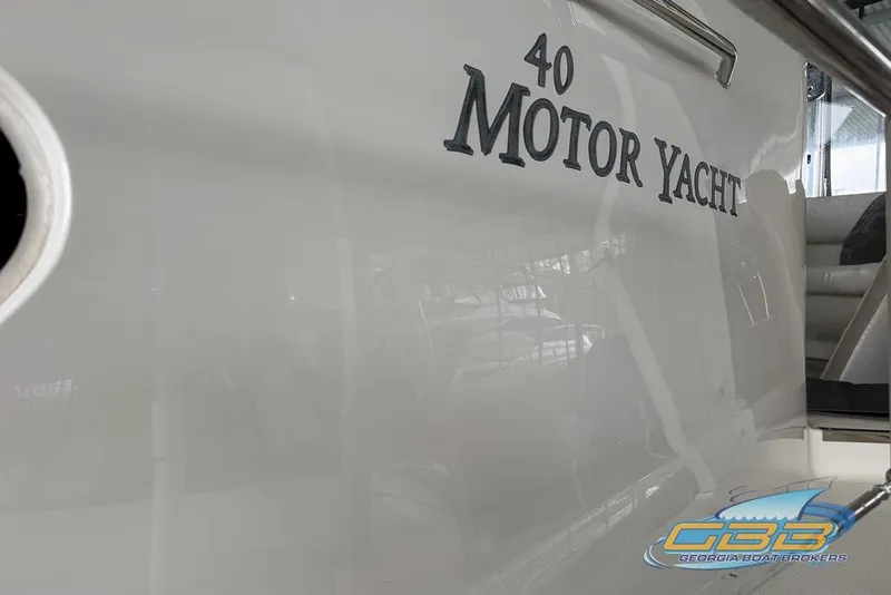 Slide: The Image of 2006 Sea Ray 40 Motor Yacht side view with logo and seating area. - 4