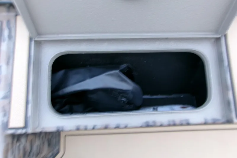 Slide: The Image of Storage compartment in 2026 Xpress X18DB boat, featuring a black bag inside. - 11