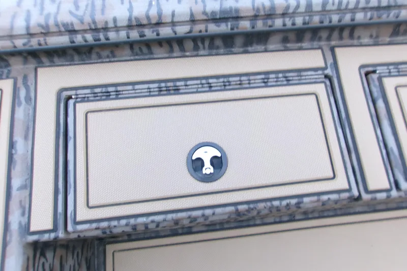 Slide: The Image of 2026 Xpress X18DB boat compartment with camouflage pattern and secure latch. - 13