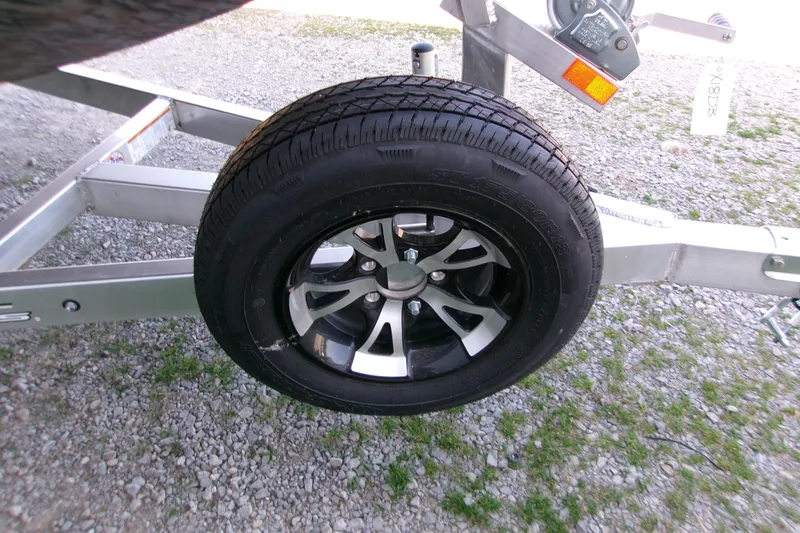 Slide: The Image of 2026 Xpress X18DB trailer wheel on gravel surface. - 14