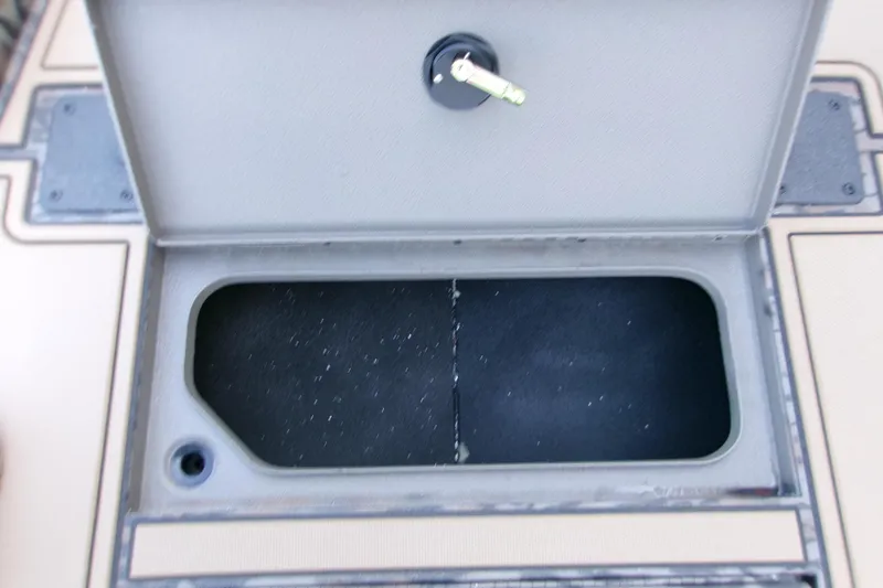 Slide: The Image of Open storage compartment on 2026 Xpress X18DB boat deck with key lock. - 15