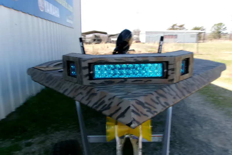 Slide: The Image of 2026 Xpress X18DB boat with camo design and blue LED lights. - 3