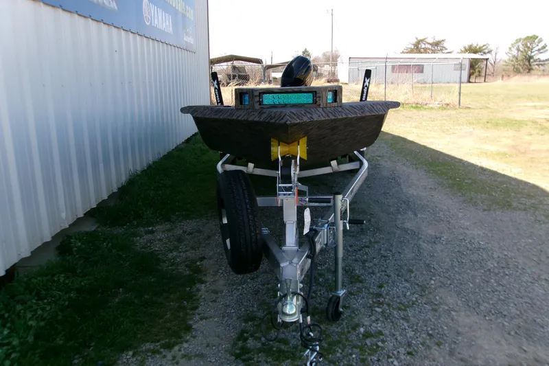 Slide: The Image of 2026 Xpress X18DB boat on trailer, parked outdoors near a metal building. - 4