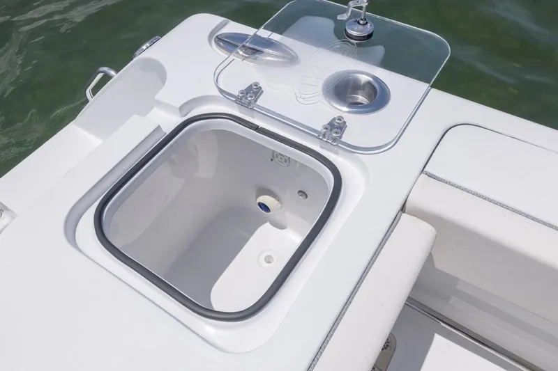 Slide: The Image of 2026 Sea Hunt Gamefish 25 boat with open storage compartment and cup holder. - 10