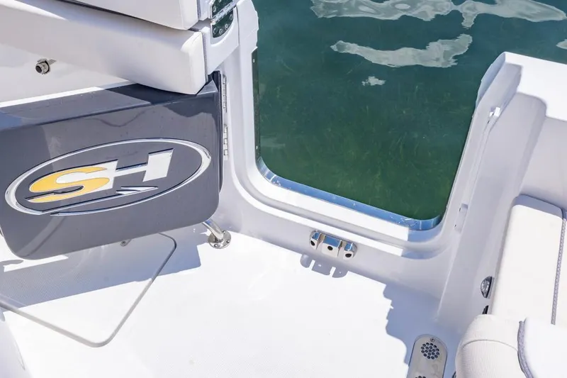 Slide: The Image of 2026 Sea Hunt Gamefish 25 boat interior with logo, overlooking clear water. - 13