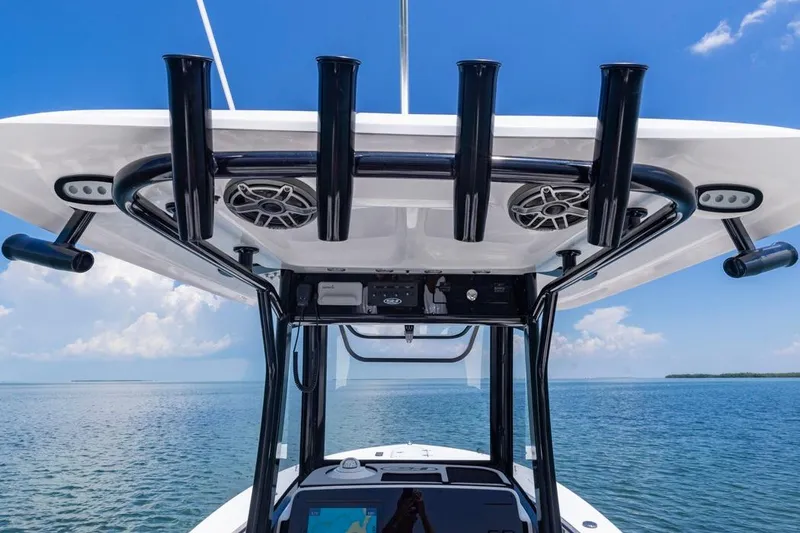 Slide: The Image of 2026 Sea Hunt Gamefish 25 boat console with rod holders and speakers, ocean view. - 18