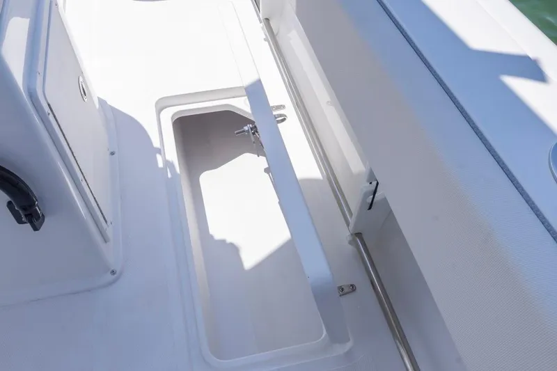 Slide: The Image of 2026 Sea Hunt Gamefish 25 boat storage compartment, open and empty, with white interior. - 23