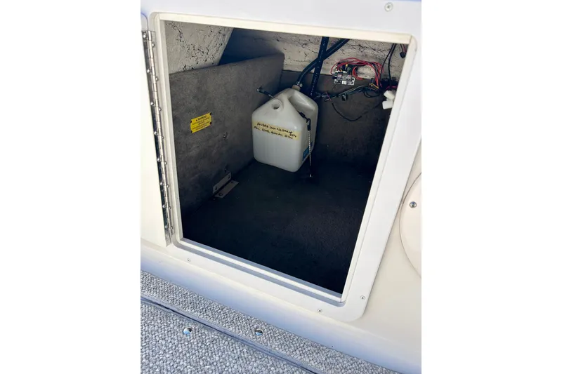 Slide: The Image of Storage compartment of 2004 Starcraft Aurora 2000 OB boat with wiring and a container. - 39