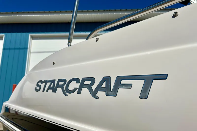 Slide: The Image of 2004 Starcraft Aurora 2000 OB boat with logo, blue building background. - 7