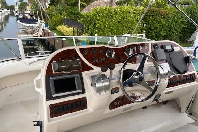 Slide: The Image of 1999 Maxum 4100 SCA yacht helm with steering wheel, controls, and navigation equipment. - 3