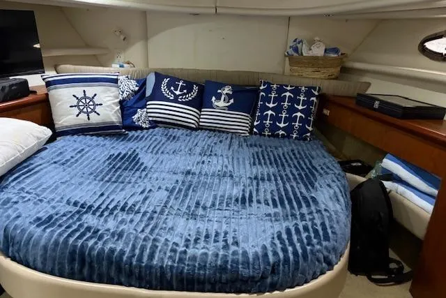Slide: The Image of Cozy cabin interior of 1999 Maxum 4100 SCA with nautical-themed bedding and decor. - 4