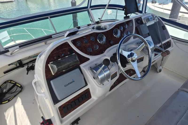 Slide: The Image of 1999 Maxum 4100 SCA yacht helm with Garmin navigation and classic steering wheel. - 7