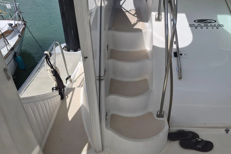 Slide: The Image of Staircase on a 1999 Maxum 4100 SCA yacht, docked with visible deck and railing. - 8