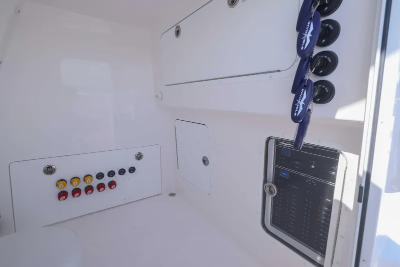Slide: The Image of 2025 Invincible 35 Catamaran control panel with switches and gauges. - 17