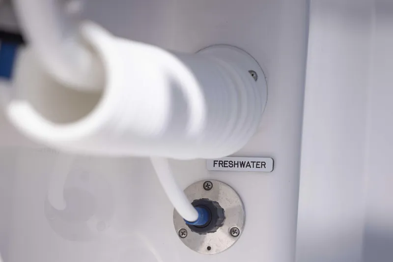 Slide: The Image of Freshwater connection on 2025 Invincible 35 Catamaran, featuring white hose and labeled port. - 35
