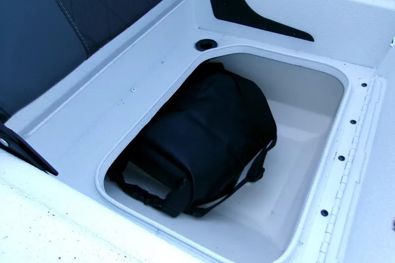 Slide: The Image of Storage compartment in 2026 Xpress H22B Bay boat with a black bag inside. - 21