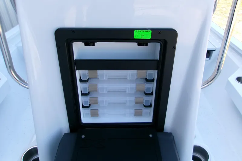Slide: The Image of 2026 Xpress H22B Bay boat storage compartment with organized tackle boxes. - 22