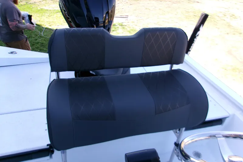 Slide: The Image of 2026 Xpress H22B Bay boat with black cushioned seating and steering wheel. - 24