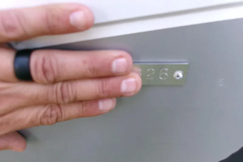 Slide: The Image of Hand covering part of a metal plate on a 2026 Xpress H22B Bay boat. - 25