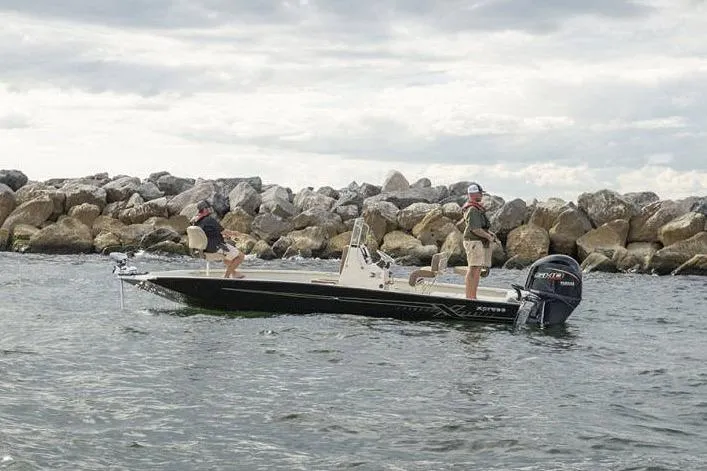 Slide: The Image of Manufacturer Provided Image: 2026 Xpress H22B Bay boat on water near rocky shoreline, two people onboard. - 27