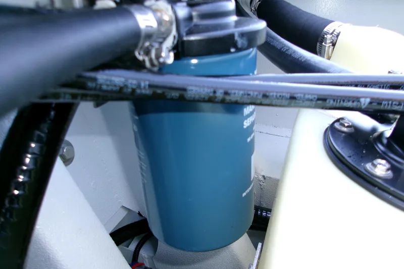 Slide: The Image of Engine compartment of 2026 Xpress H22B Bay boat, featuring hoses and a blue filter. - 7