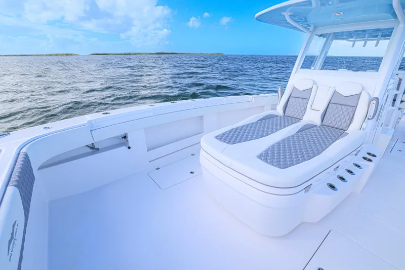 Slide: The Image of 2025 Invincible 35 Catamaran with luxurious seating, cruising on open water under a clear blue sky. - 11