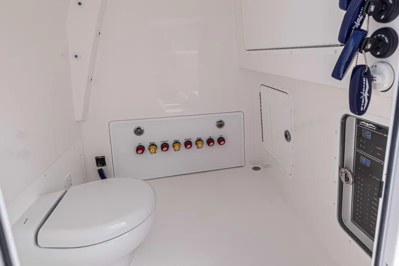 Slide: The Image of Interior of 2025 Invincible 35 Catamaran featuring a modern marine toilet and control panel. - 16