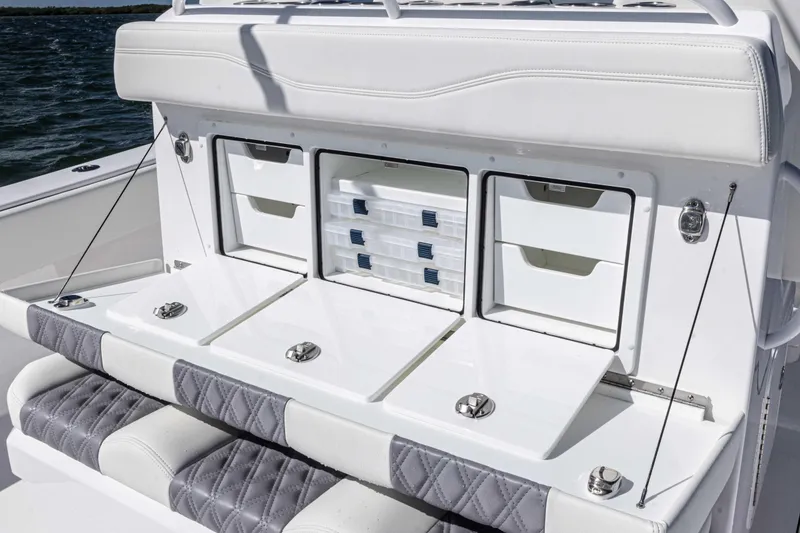 Slide: The Image of 2025 Invincible 35 Catamaran storage compartments with cushioned seating and ocean backdrop. - 20