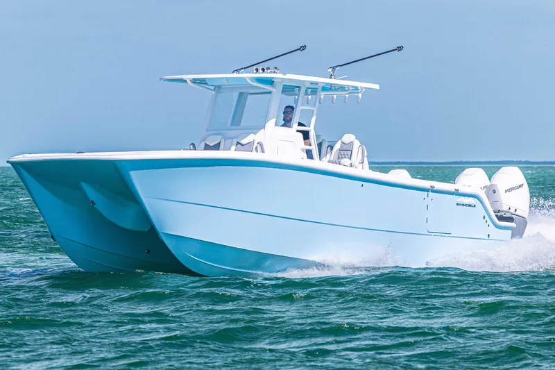 Slide: The Image of 2025 Invincible 35 Catamaran cruising on open water, showcasing sleek design and powerful engines. - 28