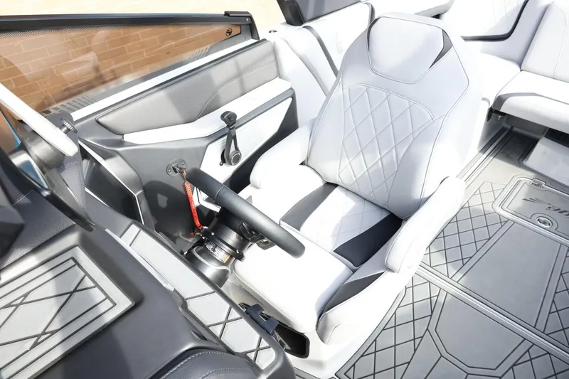 Slide: The Image of 2022 Tigé 23ZX boat interior with sleek white captain's seat and modern dashboard design. - 21