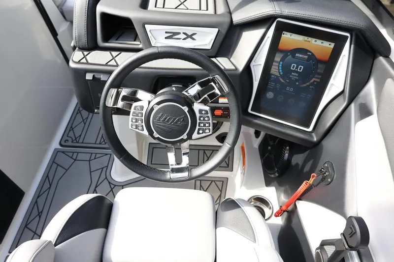 Slide: The Image of 2022 Tigé 23ZX boat dashboard with touchscreen display and steering wheel. - 22