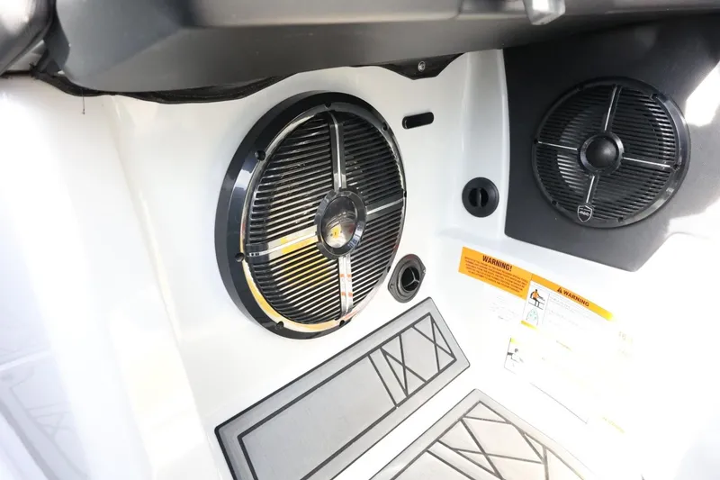 Slide: The Image of 2022 Tigé 23ZX boat interior speakers and warning labels. - 29
