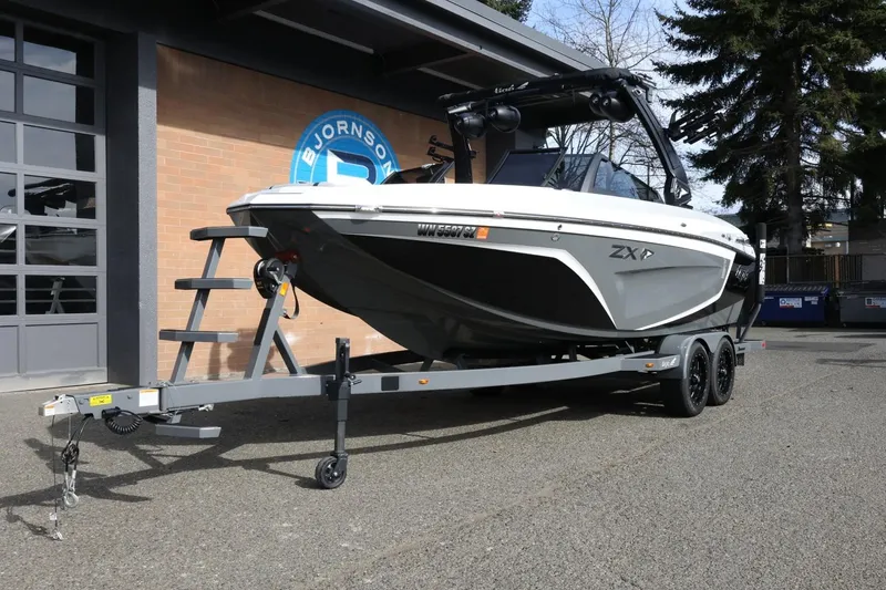 Slide: The Image of 2022 Tigé 23ZX boat on trailer outside dealership, showcasing sleek design and modern features. - 3