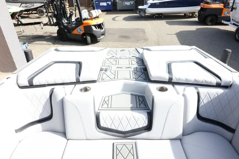 Slide: The Image of 2022 Tigé 23ZX boat interior with white cushioned seating and cup holders. - 39
