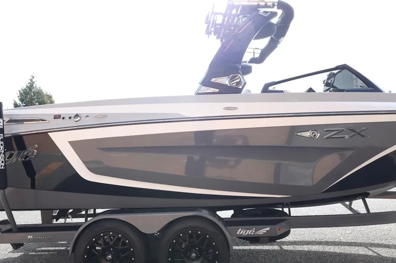 Slide: The Image of 2022 Tigé 23ZX boat on trailer, sleek design, black and white color scheme. - 6