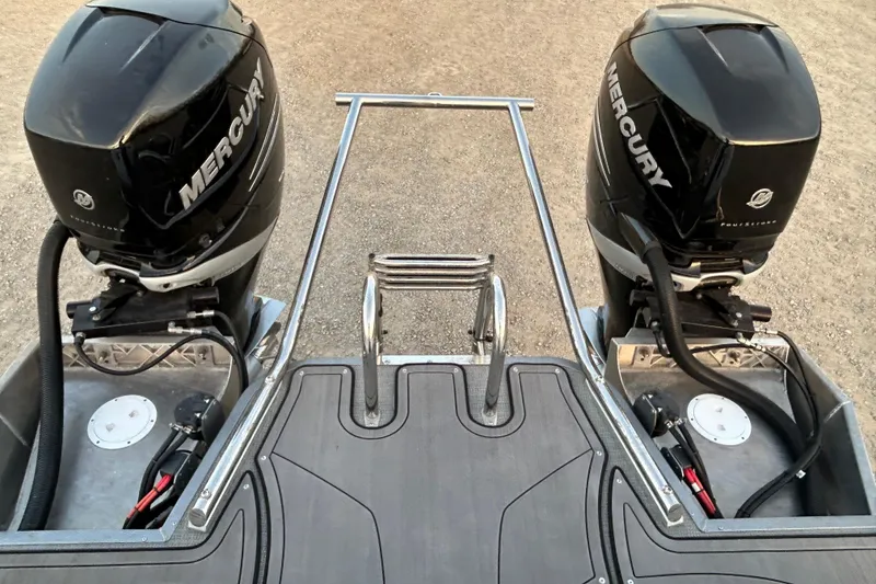 Slide: The Image of 2023 Manitou 270 boat with dual Mercury outboard engines, rear view. - 7