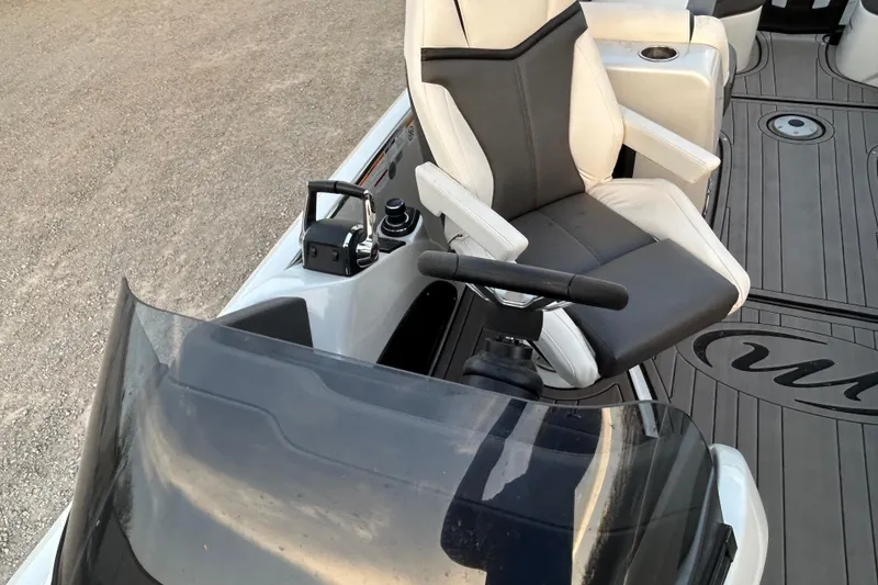 Slide: The Image of Captain's seat and controls of 2023 Manitou 270 boat, featuring sleek design and modern amenities. - 8