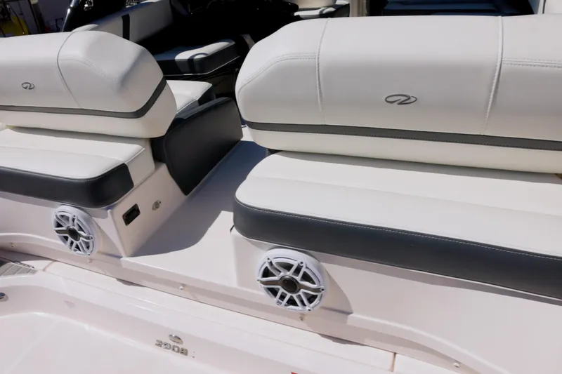 Slide: The Image of 2017 Regal 29 OBX boat interior with white cushioned seating and built-in speakers. - 14