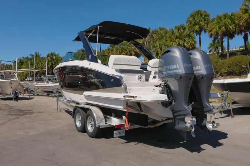 Slide: The Image of 2017 Regal 29 OBX boat with dual Yamaha engines on a trailer, surrounded by palm trees. - 16