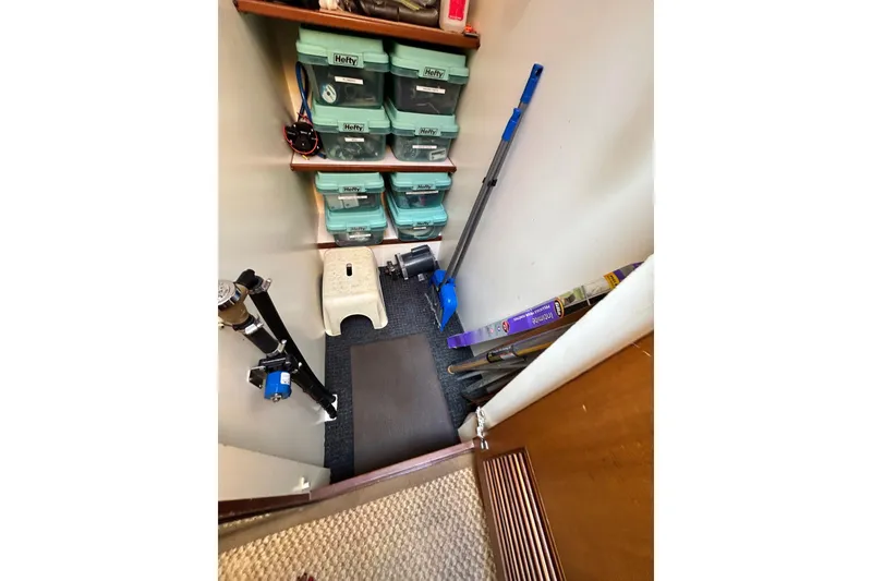 Slide: The Image of Storage area on a 1996 Jefferson 52 Rivanna Cockpit MY with organized shelves and cleaning tools. - 50