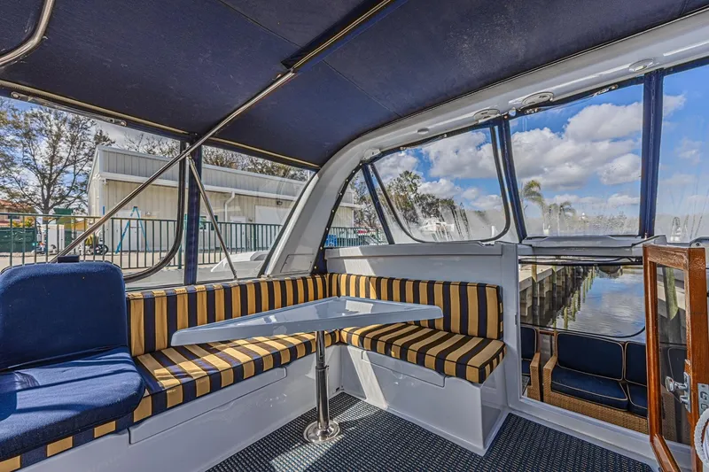 Slide: The Image of Interior of 1996 Jefferson 52 Rivanna Cockpit MY with striped seating and marina view. - 13