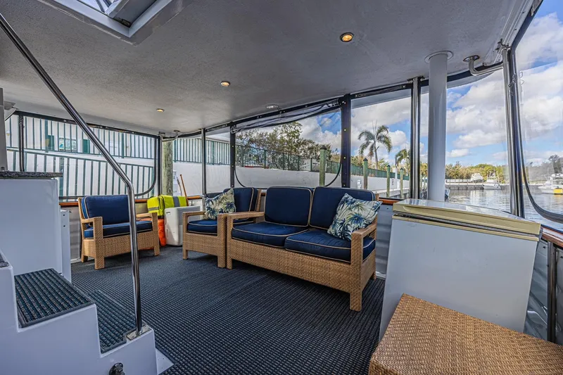 Slide: The Image of Spacious cockpit of 1996 Jefferson 52 Rivanna yacht with wicker seating and marina view. - 7