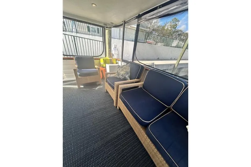 Slide: The Image of 1996 Jefferson 52 Rivanna Cockpit MY interior with wicker seating and navy cushions. - 8